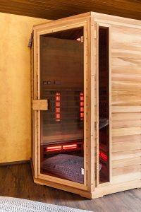 a small wooden infrarered sauna booth in a spa