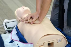 CPR First Aid Training with CPR dummy in the class