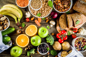 Healthy food. Selection of good carbohydrate sources, high fiber rich food. Low glycemic index diet. Fresh vegetables, fruits, cereals, legumes, nuts, greens. Wooden background copy space